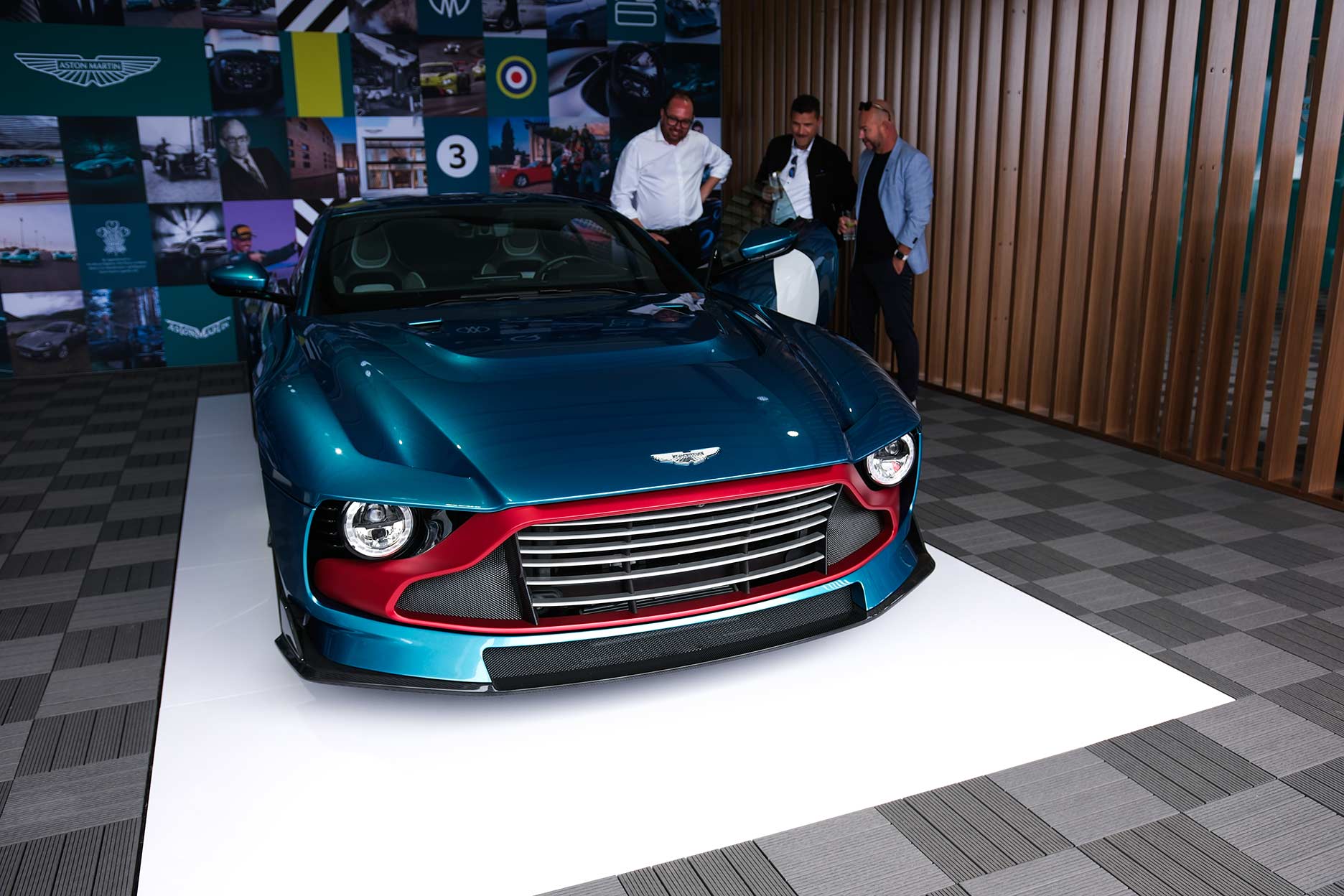 Aston Martin Valour in teal with red grille on display at Car Week 2023, viewed by guests