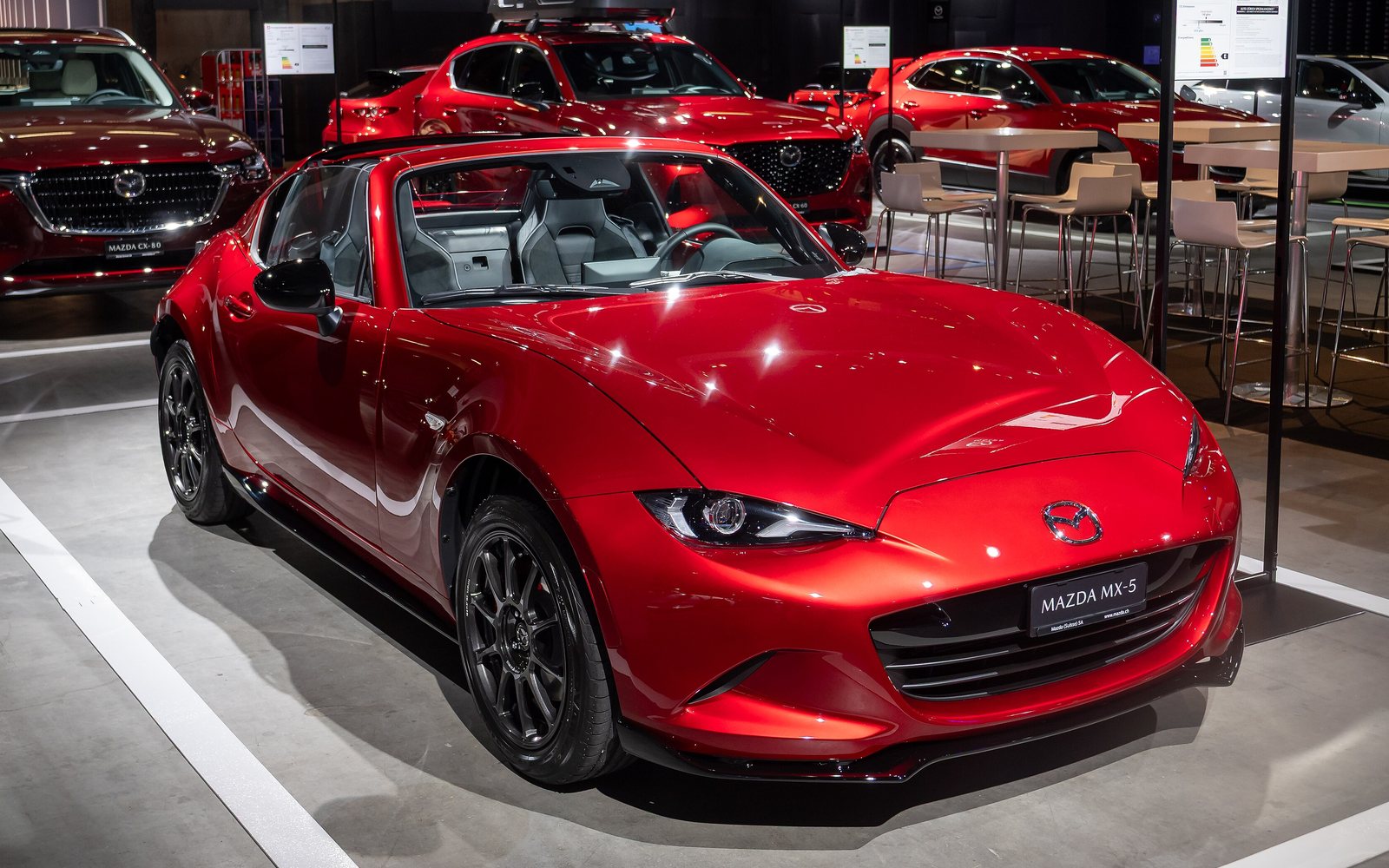 Mazda MX-5 Miata in red, front three-quarter view on a Mazda show stand
